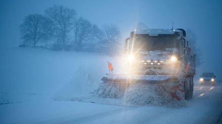 Ein Schneepflug räumt Schnee auf einer Landstraße. In Bayern haben in der Nacht starke Schneefälle eingesetzt.