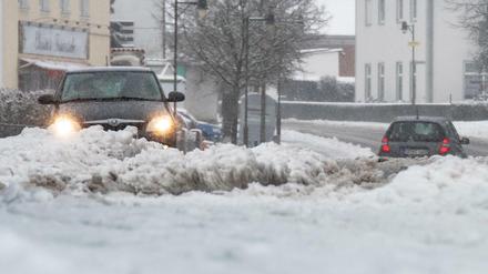 Bayern, Straßkirchen: Autos fahren auf schneebedeckten Straßen. 