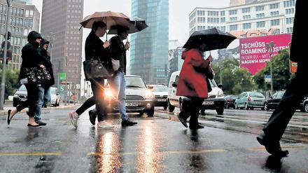 Fußgänger überqueren die Straße am Potsdamer Platz in Berlin.