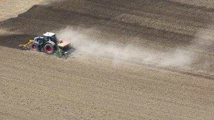 Ein Landwirt bearbeitet mit seinem Traktor ein ausgetrocknetes Feld.