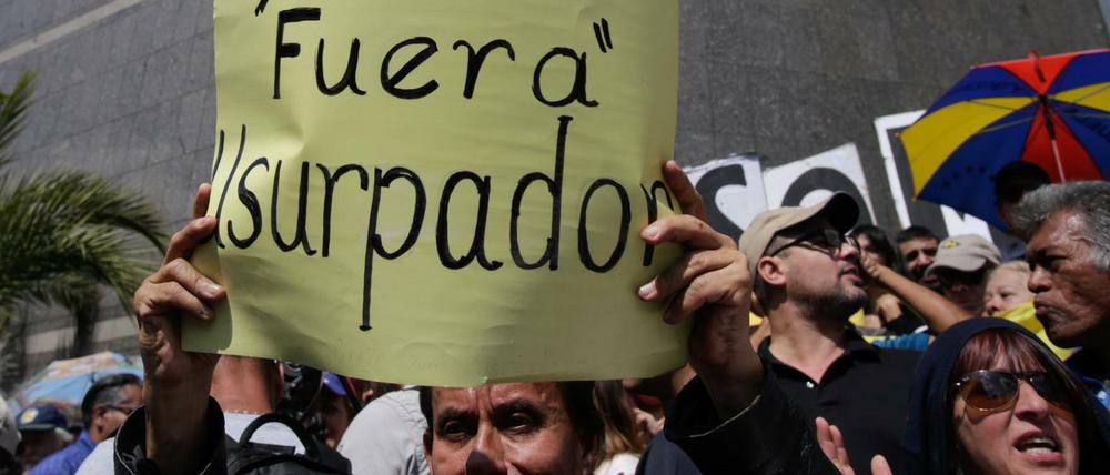 "Tyrann - raus - Usurpator", steht auf dem Plakat eines Demonstranten in Caracas.