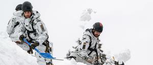 Einsatzkräfte der Bundeswehr befreien ein Dach im Umkreis von Bad Tölz von Schneemassen.