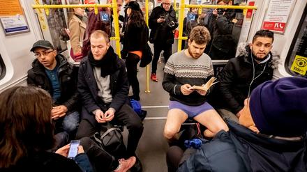 Ein Mann in Unterhose sitzt bei der Aktion "No Pants Subway Ride" in einer U-Bahn. 
