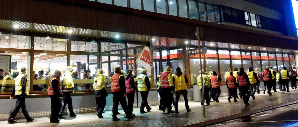Streikendes Sicherheitspersonal geht am Flughafen Schönefeld am Hauptterminal vorbei.
