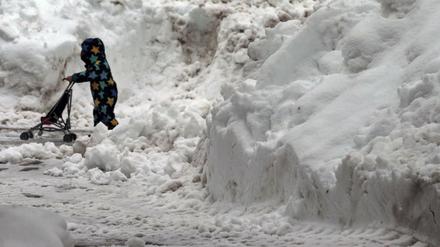 Bayern, Oberstdorf: Ein Kind läuft zwischen aufgetürmten Schneebergen.