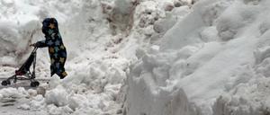 Bayern, Oberstdorf: Ein Kind läuft zwischen aufgetürmten Schneebergen.
