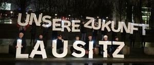 20 Menschen protestieren vor dem Kanzleramt in Berlin für Kohleverstromung. 