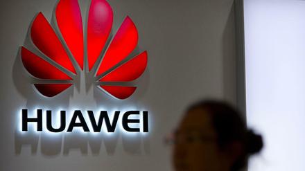 Eine Passantin blickt auf das Logo an einem Huawei Store in Peking. 