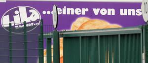 Lkw des Bäckereiunternehmens "Lila Bäcker" stehen am Produktionsstandort der Bäckerei hinter einem Zaun.