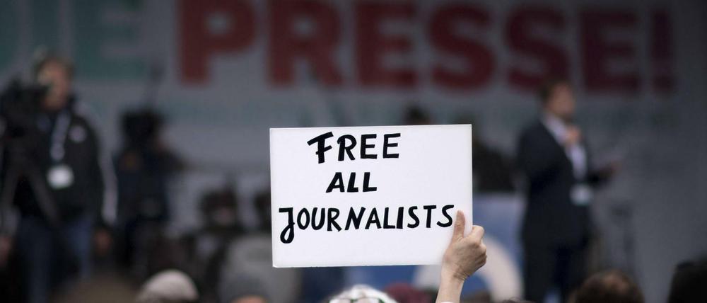 Ein Demonstrant fordert in Berlin die Freilassung von in der Türkei inhaftierten Journalisten.  