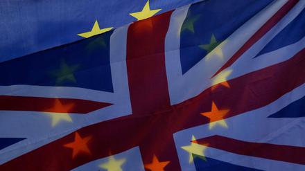 Großbritannien, London: Ein Demonstrant vor den Houses of Parliament, dem Westminster-Palast, schwenkt eine EU-Flagge und eine britische Flagge. 