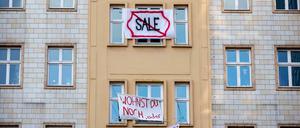 Plakate gegen den Verkauf von Mietwohnungen an die Deutsche Wohnen hängen an einer Gebäudefassade in der Karl-Marx-Allee.