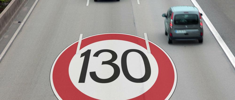 Verkehrsschild mit Höchstgeschwindigkeit 130 km/h auf dem Straßenpflaster einer Autobahn.