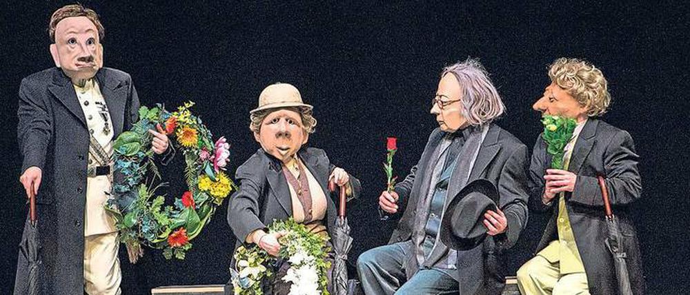 Die Maskenspieler der Theatertruppe Familie Flöz verkleidet als Trauergäste. 