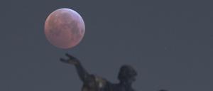 Der "Blutmond" hinter einer Mattielli-Statue auf der Katholischen Hofkirche in Dresden