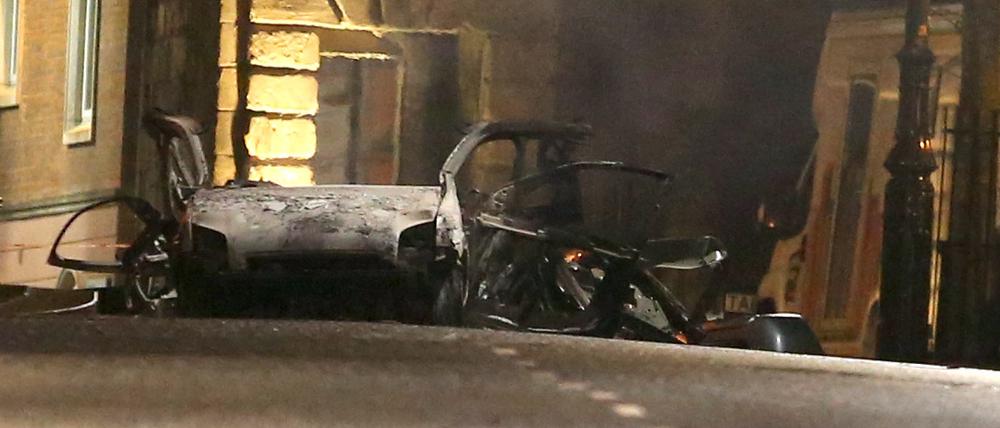 Ein zerstörtes Auto steht am Explosionsort auf der Bishop Street. Die Polizei geht Hinweisen auf eine Autobombe nach. 
