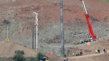 Ein Kran hält ein Stahlrohr, das den Schacht stabilisieren soll.