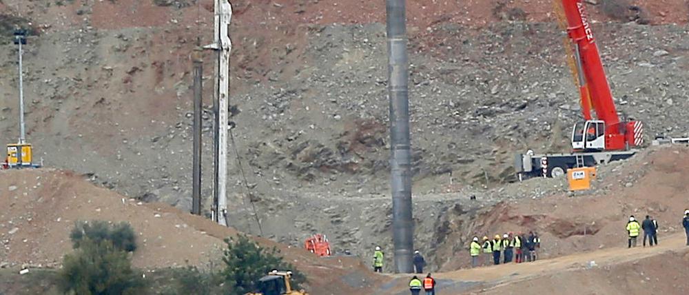 Ein Kran hält ein Stahlrohr, das den Schacht stabilisieren soll.