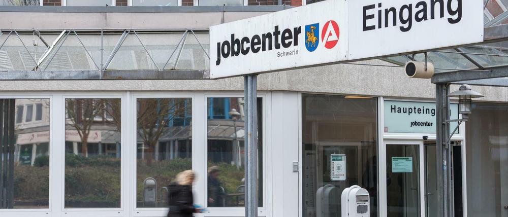 Eine Frau geht in das Jobcenter der Agentur für Arbeit.
