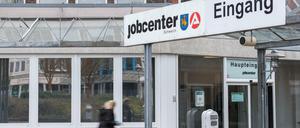 Eine Frau geht in das Jobcenter der Agentur für Arbeit.