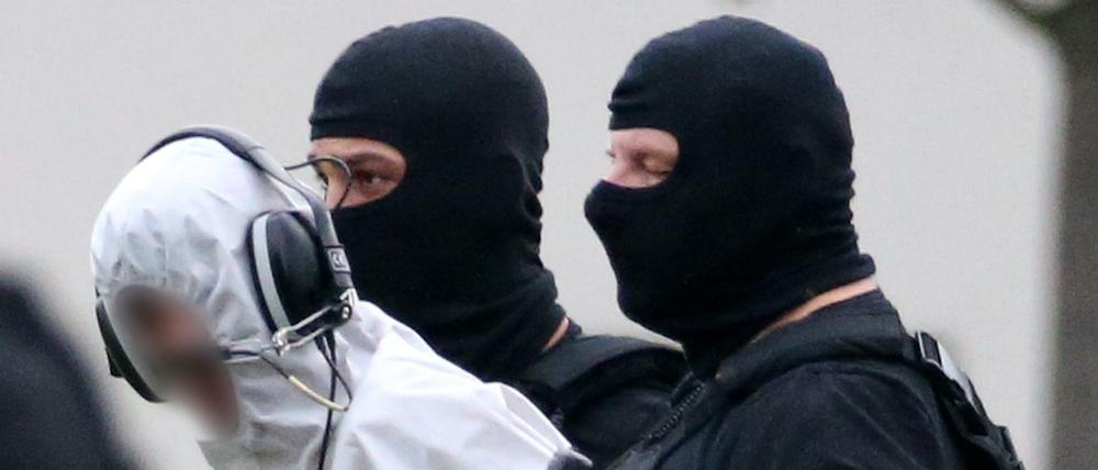 Ali B., der Tatverdächtige im Todesfall Susanna, wird von Beamten zu einem Polizeihubschrauber gebracht