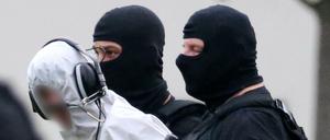 Ali B., der Tatverdächtige im Todesfall Susanna, wird von Beamten zu einem Polizeihubschrauber gebracht 