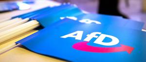 Fähnchen mit dem Logo der AfD liegen beim Landesparteitag der AfD Bayern auf einem Tisch.