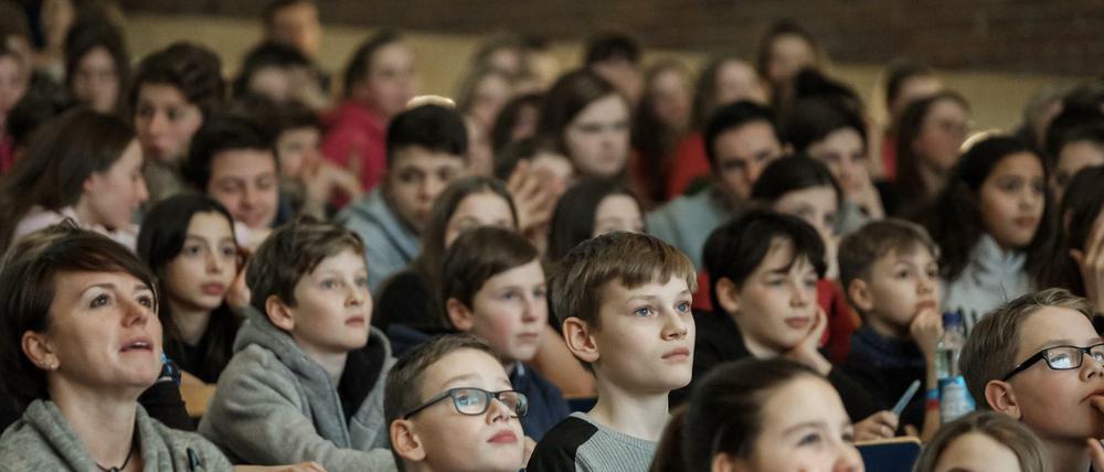 Spannung im Hörsaal. Die Schülerinnen und Schüler warten, dass sie auf die Bühne gerufen werden. 