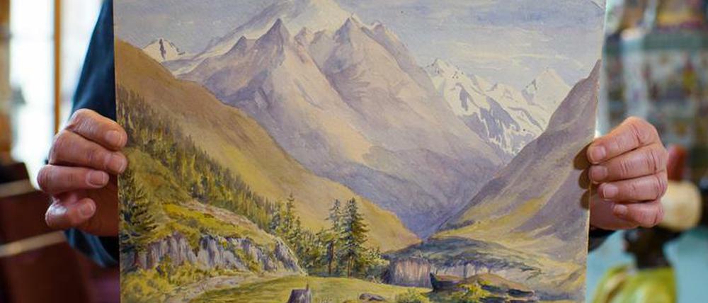 Entzückende Ansichten. Ein Mitarbeiter des Auktionshauses Kloss hält ein angeblich von Adolf Hitler 1911 gemaltes Landschaftsaquarell ("Niederthal, Vent") in Händen.