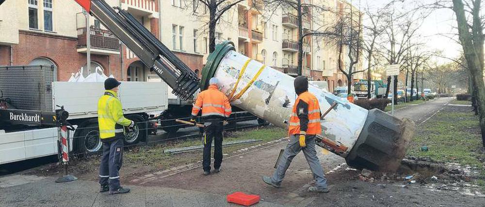 Arbeiter entfernen im Auftrag der Wall AG eine Litfaßsäule in der Wichertstraße in Prenzlauer Berg.