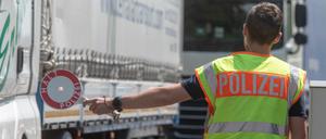 Ein Polizist steht mit einer Kelle an einer Kontrollstelle der Bundespolizei auf der Autobahn 3 in Bayern. 
