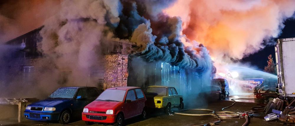Dichter Qualm tritt unter dem Dach der brennenden Lagerhalle hervor.