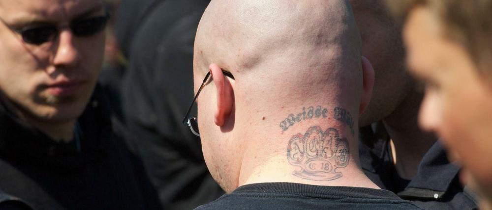 Ein Neonazi-Skinhead mit einem Tattoo eines Schlagrings. Das Kürzel "C18" steht für die Neonazi-Gruppe Combat 18.