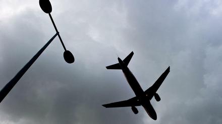 Flugzeug vor dunklen Wolken am Himmel.