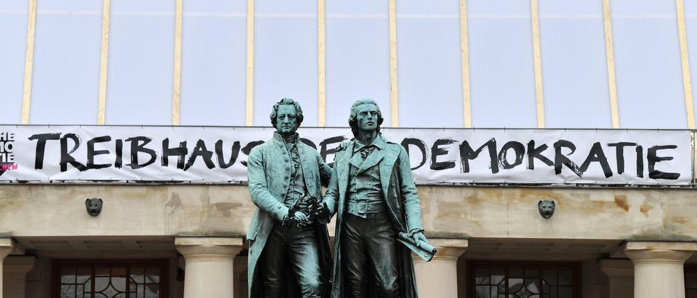 Treibhaus der Demokratie steht an der Fassade des Deutschen Nationaltheater hinter dem Goethe-Schiller-Denkmal. Hier trat vor 100 Jahren dei Nationalversammlung zusammen.