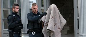 Polizisten führen einen verdächtigen Mann nach einer Razzia im Ortsteil Tiergarten ab. (Archivbild vom August 2018)
