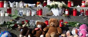 Stofftiere, Blumen und Kerzen haben Menschen vor dem Eingang zur Hausotter Grundschule in Reinickendorf abgelegt. 