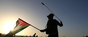 Palästinensische Demonstranten schleudern Steine und halten Flaggen bei Zusammenstößen mit israelischen Soldaten. Archivbild vom Januar.