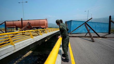 Kolumbianische Polizisten betrachten die von Venezuela gesperrte Brücke.