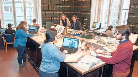 Studierende arbeiten am großen Tisch der Fotothek in der Winckelmann-Bibliothek.