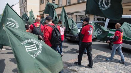 Anhänger der rechtsextremen Partei "Der III. Weg" marschieren mit Fahnen.