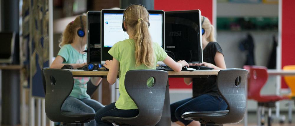 Schüler sitzen an einem Computer-Arbeitsplatz. 