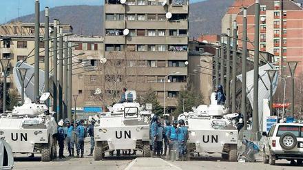 Eine UN-Polizeitruppe hält im März 2004 Kosovo-Albaner und Kosovo-Serben in der ethnisch geteilten Stadt Kosovska Mitrovica auf Distanz. 
