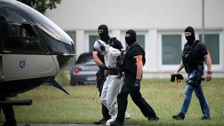 Der Verdächtige Ali B. wird zu einem Polizeihubschrauber gebracht und in eine Justizvollzugsanstalt geflogen. 