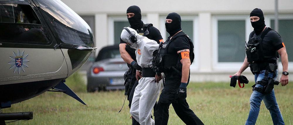 Der Verdächtige Ali B. wird zu einem Polizeihubschrauber gebracht und in eine Justizvollzugsanstalt geflogen.