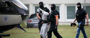 Der Verdächtige Ali B. wird zu einem Polizeihubschrauber gebracht und in eine Justizvollzugsanstalt geflogen. 