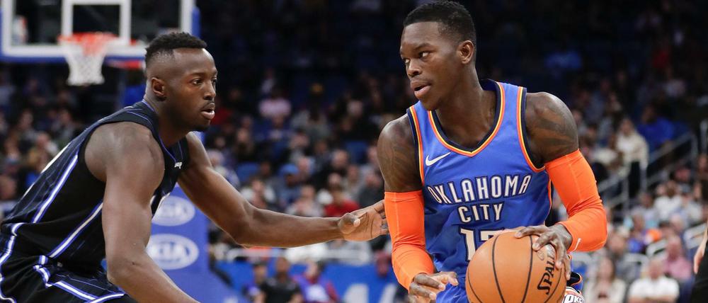 Dennis Schröder (M) von Oklahoma in Aktion gegen Jerian Grant (l) von Orlando.