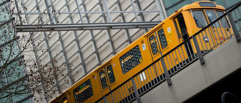 Eine U-Bahn fährt unter einem Schild mit der Aufschrift "BVG" vorbei.