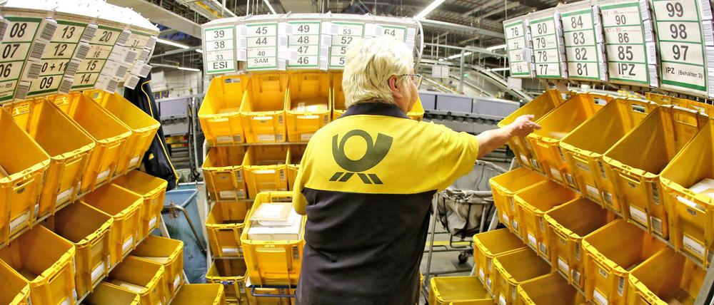 Eine Mitarbeiterin der Deutschen Post sortiert Großbriefe im Briefzentrum.