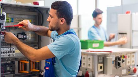 Der 19-jährige Mohammad aus Afghanistan arbeitet im Ausbildungszentrum der Siemens Professional Education an der Verdrahtung eines Schaltschranks. 